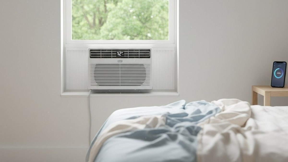 Modern bedroom with a smart window air conditioner installed in the window and a smartphone displaying a climate control app on a side table